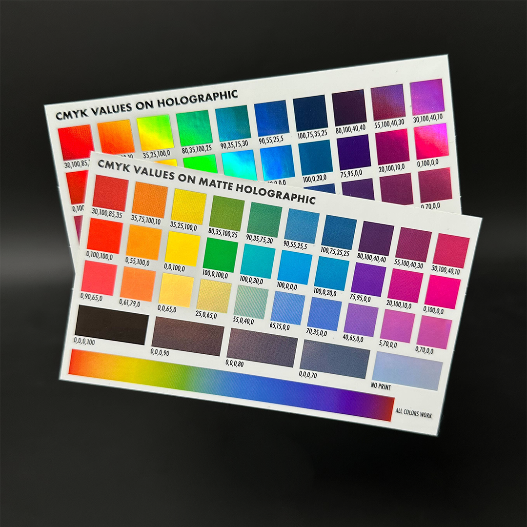 Two printed charts displaying CMYK values on holographic and matte holographic backgrounds, featuring a range of vibrant colors.
