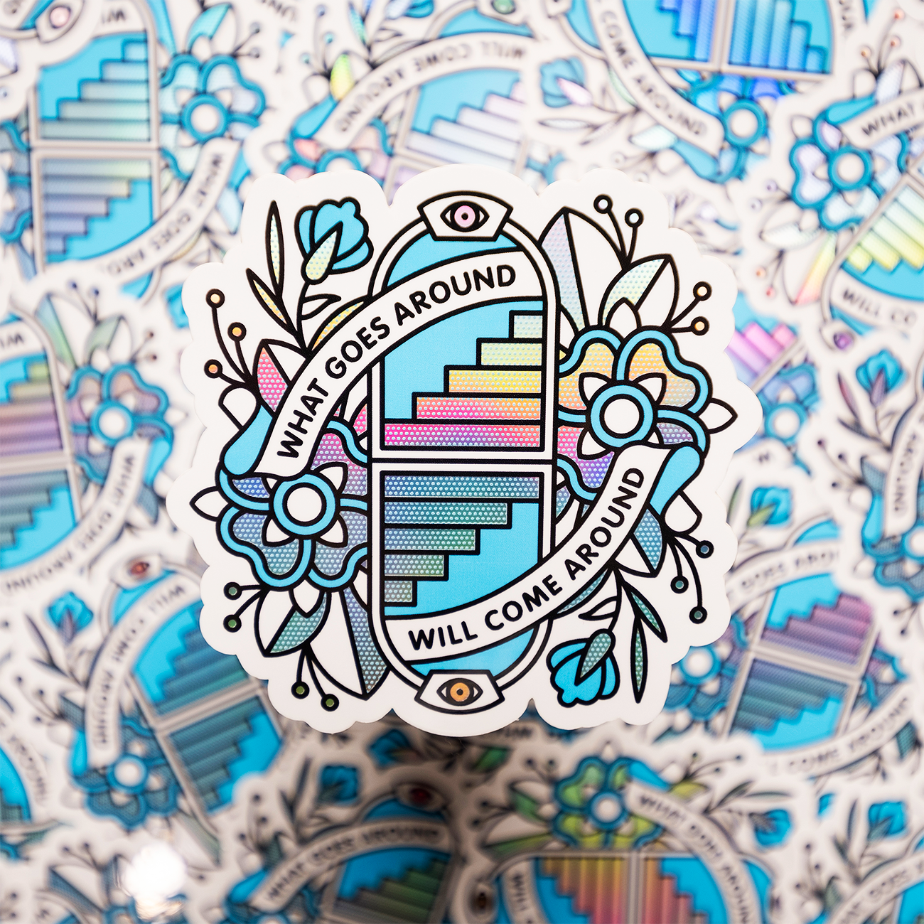 Die-Cut Sticker with floral design, stairs, and eyes, featuring the phrase "WHAT GOES AROUND WILL COME AROUND" on a patterned background.
