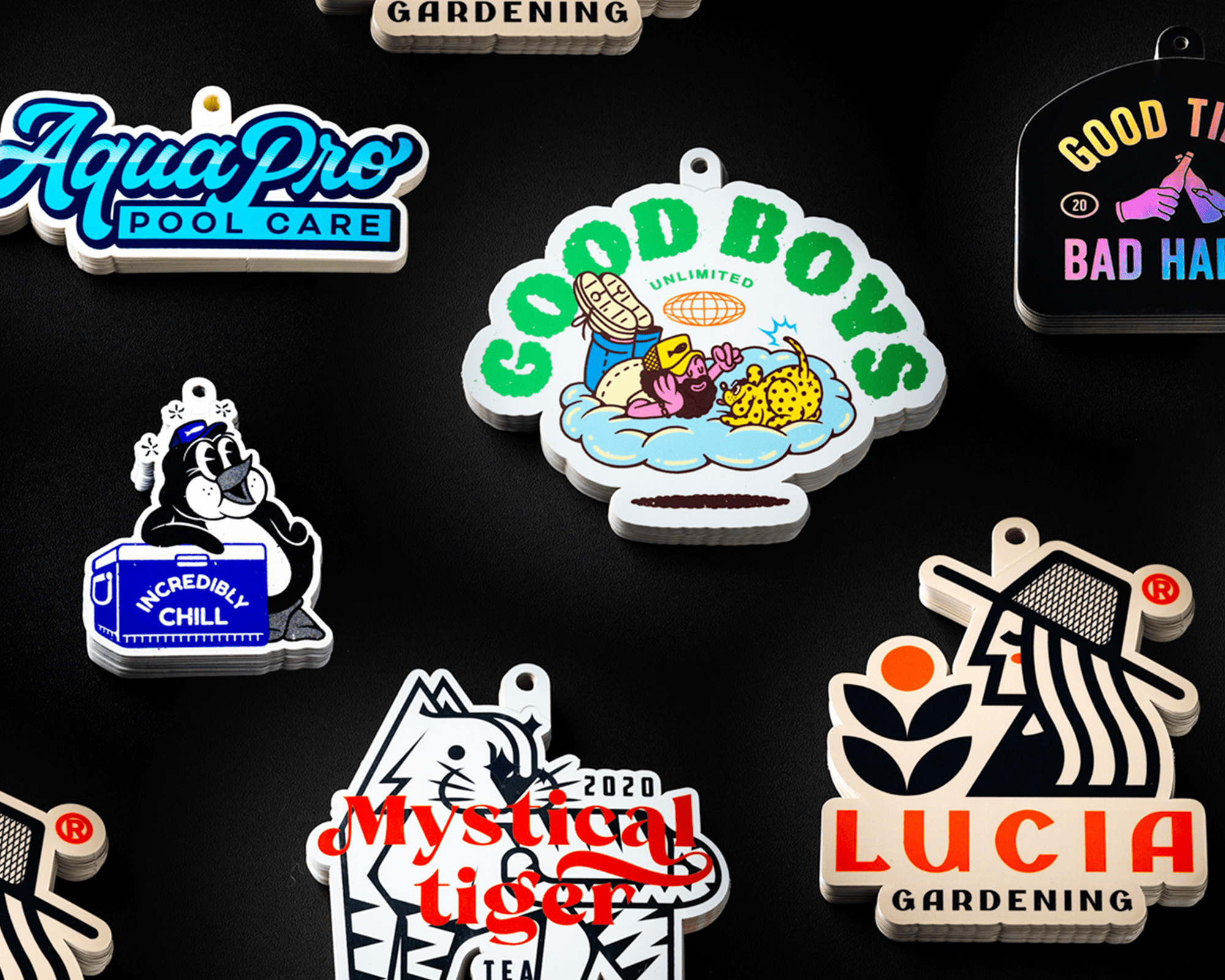A collection of colorful, illustrated hang tags featuring logos and playful designs on a black background.